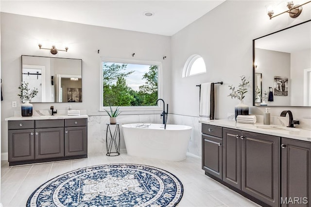 776 Hillenkamp Dr, Weldon Spring, MO 63304 - bathroom with two vanities, a soaking tub, tile walls, and a wainscoted wall