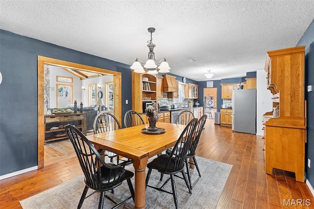 2004 Possum Hollow Rd, Farmington, MO 63640 - dining space featuring wood-type flooring, a textured ceiling, a chandelier, and baseboards