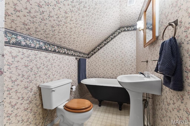 2004 Possum Hollow Rd, Farmington, MO 63640 - bathroom featuring a soaking tub, wallpapered walls, and toilet