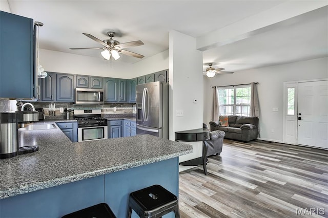 505 Lias Way, Wentzville, MO 63385 - kitchen with stainless steel appliances, a ceiling fan, a peninsula, backsplash, and dark countertops