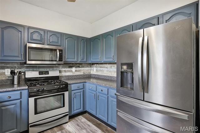 505 Lias Way, Wentzville, MO 63385 - kitchen with appliances with stainless steel finishes, dark countertops, blue cabinets, and tasteful backsplash