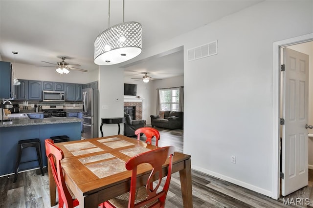 505 Lias Way, Wentzville, MO 63385 - dining room featuring ceiling fan, dark wood-type flooring, and a fireplace