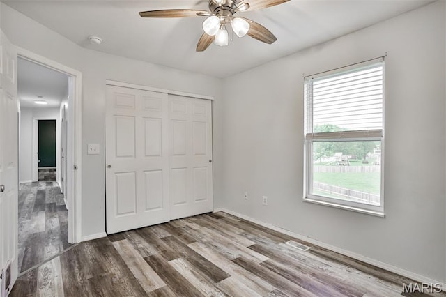 505 Lias Way, Wentzville, MO 63385 - unfurnished bedroom featuring multiple windows, wood finished floors, a closet, and a ceiling fan