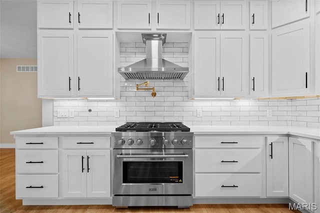 63 Plackemeier Dr, Ofallon, MO 63366 - kitchen with high end stainless steel range, wall chimney range hood, light countertops, and white cabinetry