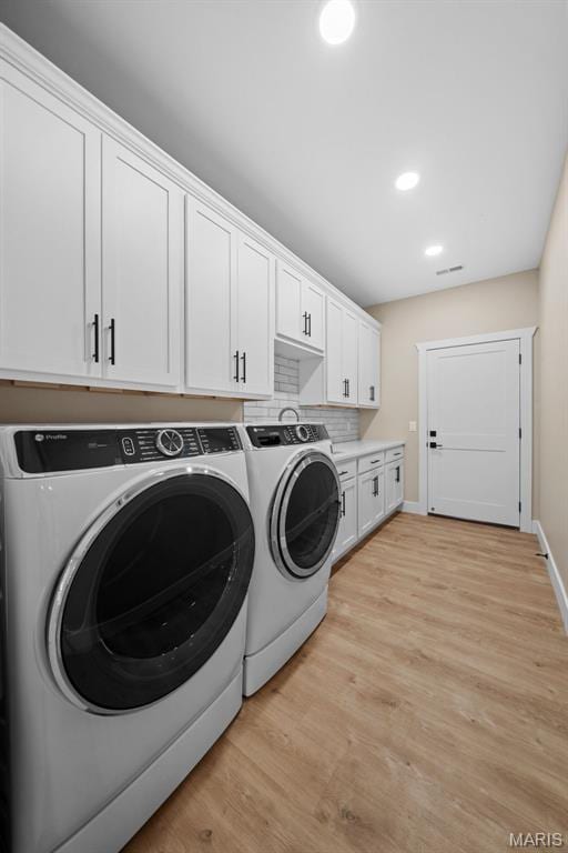 63 Plackemeier Dr, Ofallon, MO 63366 - washroom featuring washer and dryer, light wood-type flooring, recessed lighting, baseboards, and cabinet space