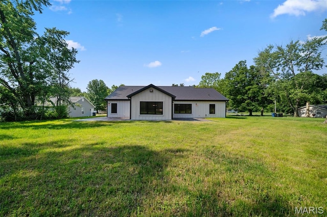 63 Plackemeier Dr, Ofallon, MO 63366 - rear view of property featuring board and batten siding, metal roof, and a yard