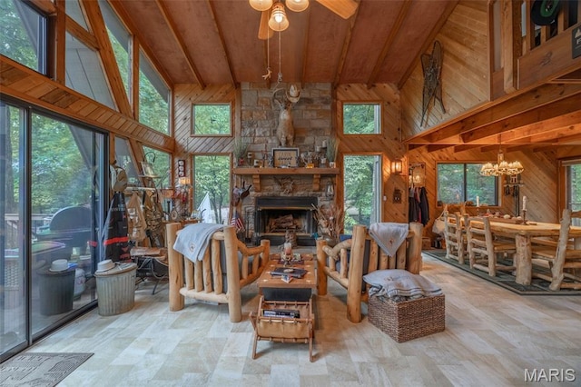 483 Hummingbird View Dr, Innsbrook, MO 63390 - living room with wood walls, a ceiling fan, a chandelier, a towering ceiling, and a stone fireplace