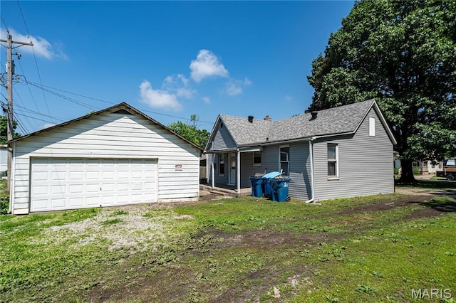2428 E 25th St, Granite City, IL 62040 - rear view of property featuring an outbuilding, a garage, a shingled roof, and a yard