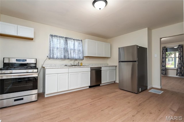 2428 E 25th St, Granite City, IL 62040 - kitchen with appliances with stainless steel finishes, a sink, light countertops, light wood finished floors, and baseboards
