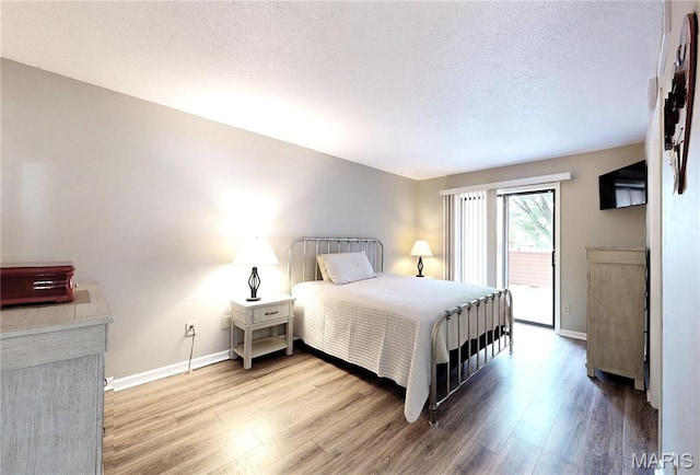 408 Kipling Way Unit A, Weldon Spring, MO 63304 - bedroom with wood finished floors, access to outside, and a textured ceiling