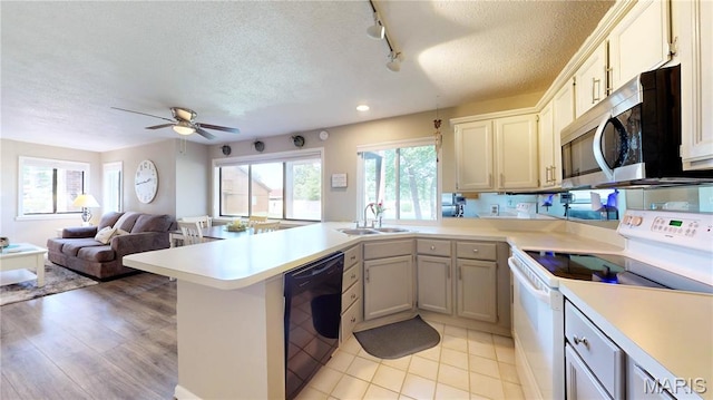 408 Kipling Way Unit A, Weldon Spring, MO 63304 - kitchen with white range with electric cooktop, black dishwasher, a peninsula, a textured ceiling, and stainless steel microwave