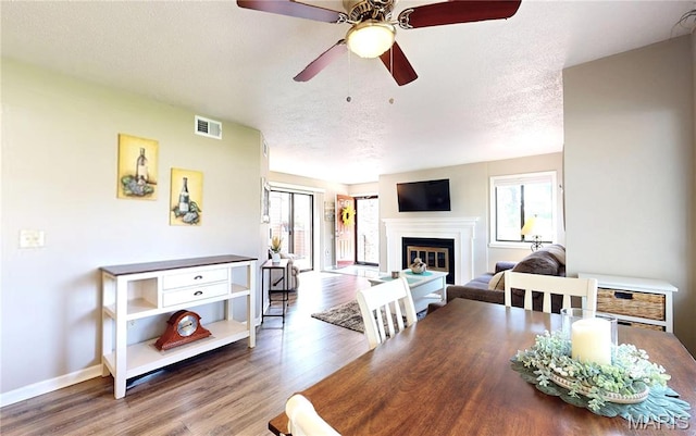 408 Kipling Way Unit A, Weldon Spring, MO 63304 - dining area with plenty of natural light, wood finished floors, ceiling fan, a textured ceiling, and a glass covered fireplace