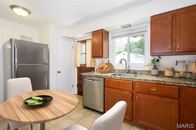 7870 Trenton Ave, University City, MO 63130 - kitchen featuring stainless steel appliances, light stone countertops, and light tile patterned floors