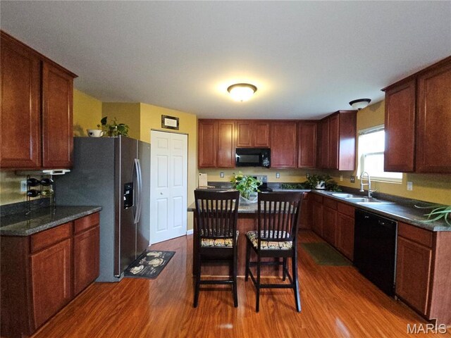 1751 Briarmanor Dr, Lake St Louis, MO 63367 - kitchen with black appliances, wood finished floors, dark countertops, and a center island
