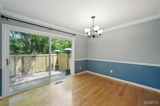 811 Wendevy Ct, Ballwin, MO 63011 - spare room featuring plenty of natural light, a chandelier, ornamental molding, and hardwood / wood-style flooring