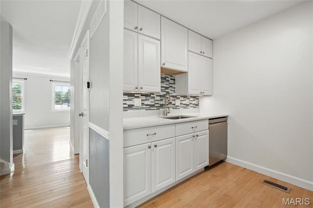 811 Wendevy Ct, Ballwin, MO 63011 - kitchen featuring dishwasher, tasteful backsplash, light wood-style flooring, and white cabinetry