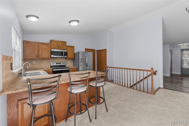 1203 Summerwood Dr, Saint Peters, MO 63376 - kitchen with stainless steel appliances, brown cabinets, light countertops, lofted ceiling, and backsplash