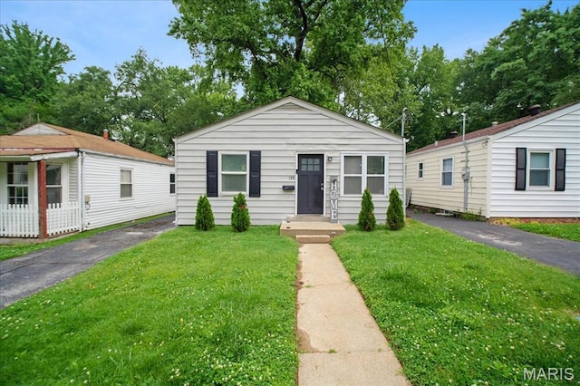 135 Anabel Ave, Saint Louis, MO 63135 - view of front of property featuring a front lawn, asphalt driveway, and view of scattered trees