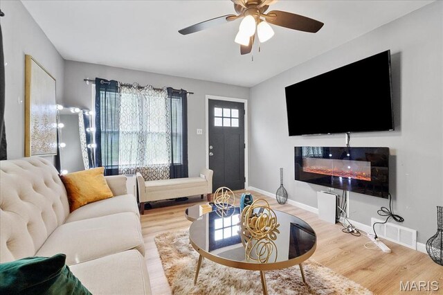 135 Anabel Ave, Saint Louis, MO 63135 - living room featuring wood finished floors, ceiling fan, a glass covered fireplace, and baseboards