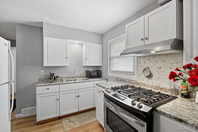135 Anabel Ave, Saint Louis, MO 63135 - kitchen with gas stove, a sink, freestanding refrigerator, light wood-type flooring, and black microwave