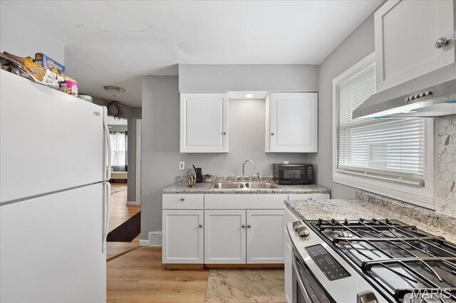 135 Anabel Ave, Saint Louis, MO 63135 - kitchen with freestanding refrigerator, gas range, a sink, light countertops, and white cabinets