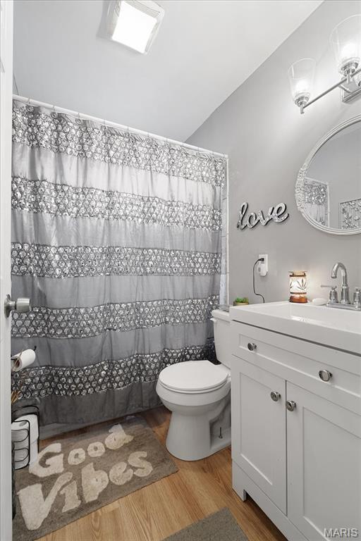 135 Anabel Ave, Saint Louis, MO 63135 - full bath with toilet, vanity, wood finished floors, and curtained shower