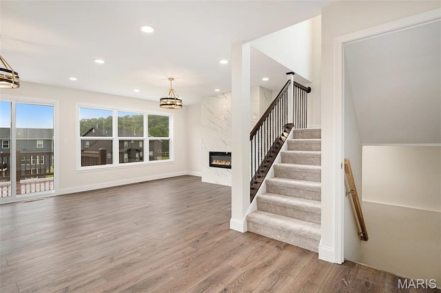 685 Fox Creek Dr, Fenton, MO 63026 - stairs featuring a chandelier, healthy amount of natural light, wood finished floors, a high end fireplace, and recessed lighting