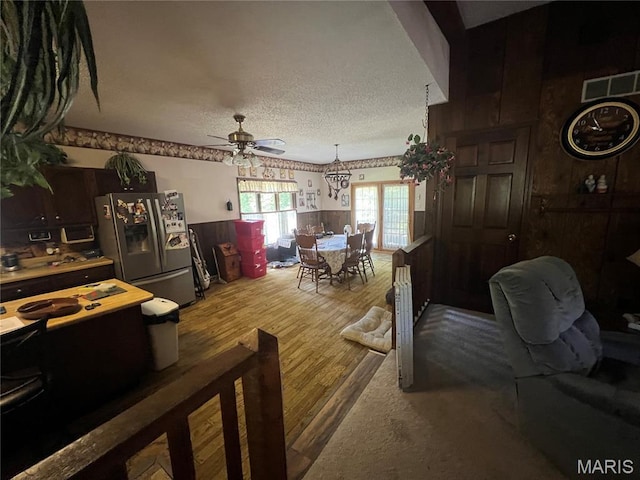 32 Bobwhite Ln, Troy, MO 63379 - dining room with a ceiling fan, wood finished floors, a wainscoted wall, and a textured ceiling