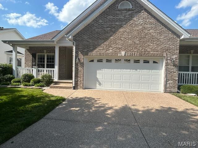 265 Strayhorn Dr, Saint Peters, MO 63376 - view of front of home featuring brick siding, a garage, a porch, and concrete driveway