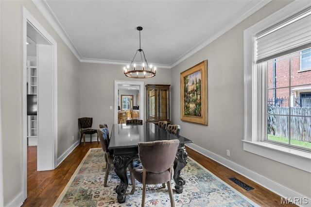 309 S Spanish Cpe, Girardeau, MO 63701 - dining room featuring healthy amount of natural light, a chandelier, dark wood finished floors, baseboards, and crown molding