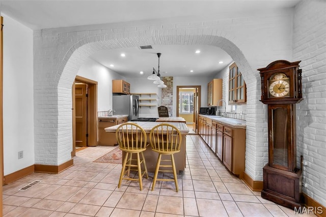 309 S Spanish Cpe, Girardeau, MO 63701 - dining space with arched walkways, light tile patterned floors, recessed lighting, baseboards, and brick wall