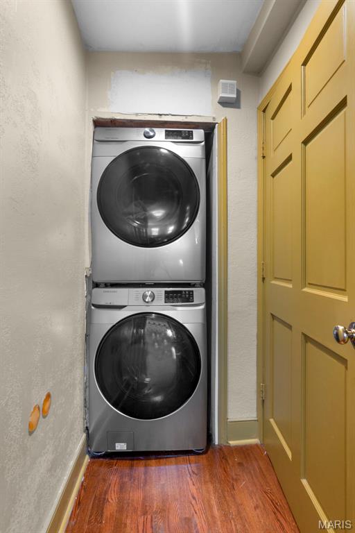 309 S Spanish Cpe, Girardeau, MO 63701 - washroom with stacked washing machine and dryer, wood finished floors, and baseboards