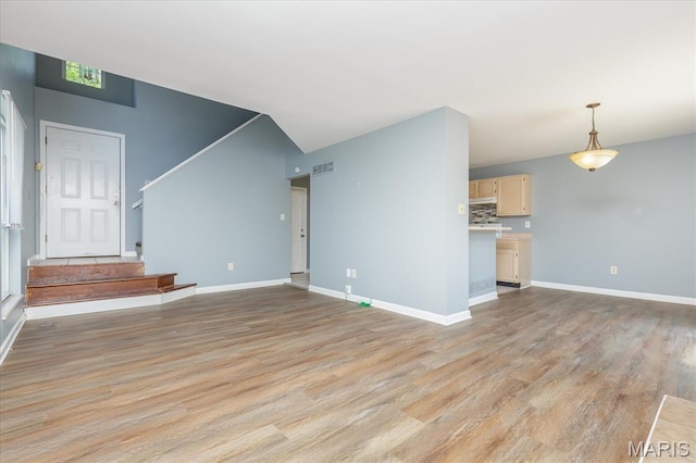 11256 Liberty Landing Dr, Florissant, MO 63033 - unfurnished living room featuring light wood-type flooring, baseboards, and stairway