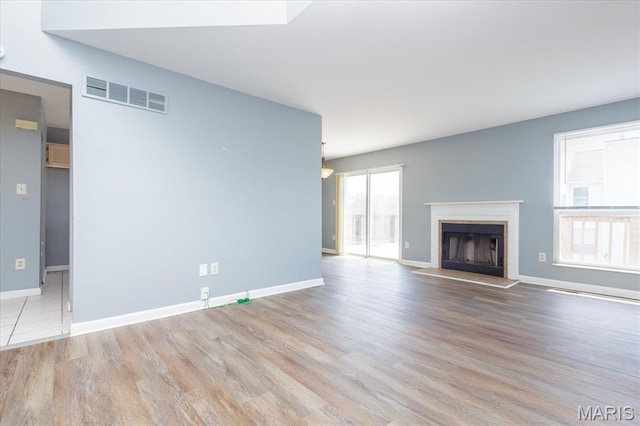 11256 Liberty Landing Dr, Florissant, MO 63033 - unfurnished living room featuring wood finished floors, baseboards, and a fireplace with raised hearth