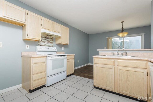 11256 Liberty Landing Dr, Florissant, MO 63033 - kitchen with white range with electric stovetop, a sink, under cabinet range hood, light countertops, and light brown cabinetry