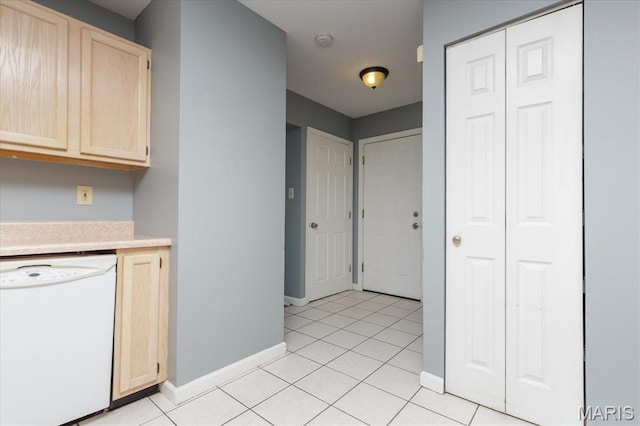 11256 Liberty Landing Dr, Florissant, MO 63033 - kitchen with white dishwasher, light brown cabinetry, light countertops, baseboards, and light tile patterned floors
