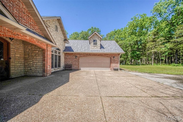 10660 Fawn Rdg, Rolla, MO 65401 - view of home's exterior featuring driveway, an attached garage, a shingled roof, brick siding, and a yard
