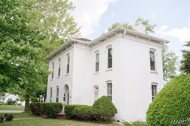 124 W Ross St, Palmyra, MO 63461 - view of side of property with a chimney, brick siding, and a yard