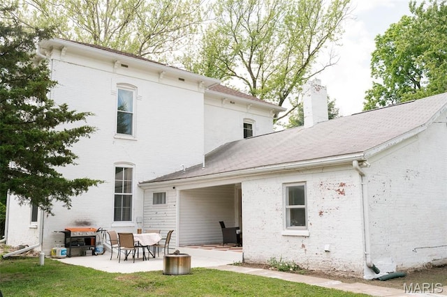 124 W Ross St, Palmyra, MO 63461 - rear view of property with a patio area, a chimney, brick siding, and a lawn