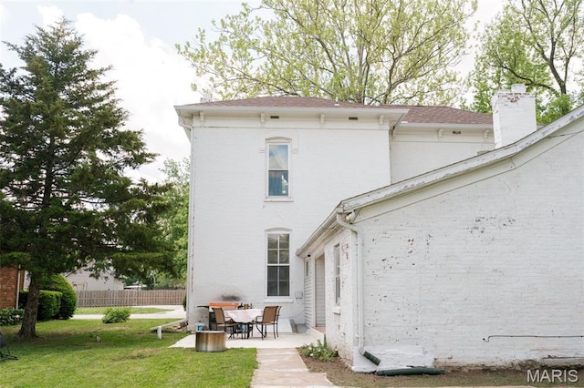 124 W Ross St, Palmyra, MO 63461 - back of house with a patio area, a chimney, and brick siding