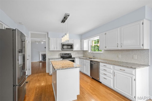 12101 Fahrpark Ln, Saint Louis, MO 63146 - kitchen with appliances with stainless steel finishes, white cabinets, decorative backsplash, and light wood-style flooring
