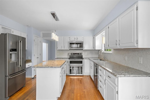 12101 Fahrpark Ln, Saint Louis, MO 63146 - kitchen with stainless steel appliances, a kitchen island, white cabinetry, and backsplash