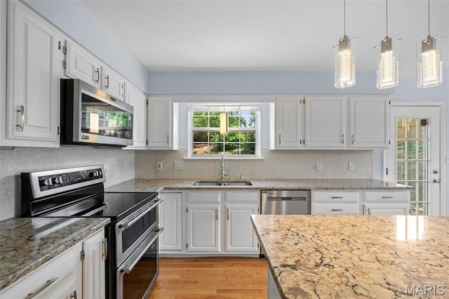 12101 Fahrpark Ln, Saint Louis, MO 63146 - kitchen featuring stainless steel appliances, light wood-style flooring, white cabinetry, and decorative backsplash