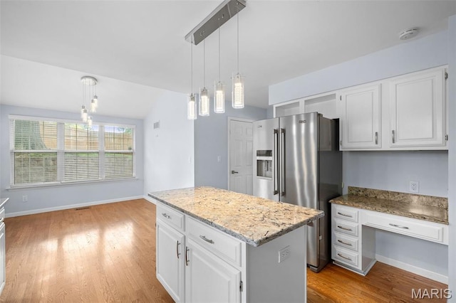 12101 Fahrpark Ln, Saint Louis, MO 63146 - kitchen featuring high quality fridge, a center island, light wood finished floors, white cabinets, and decorative light fixtures