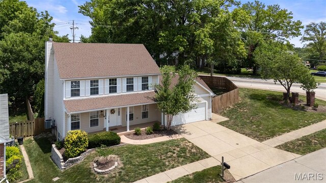 12101 Fahrpark Ln, Saint Louis, MO 63146 - colonial inspired home with covered porch, concrete driveway, a chimney, a garage, and roof with shingles