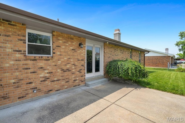 3100 Tally Ho Dr, Saint Charles, MO 63301 - back of house with a patio, a chimney, a yard, brick siding, and entry steps