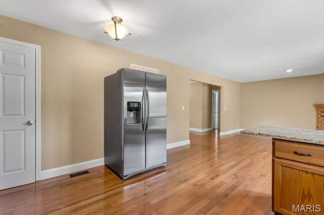 3100 Tally Ho Dr, Saint Charles, MO 63301 - kitchen with stainless steel fridge with ice dispenser, light wood-style floors, and brown cabinets