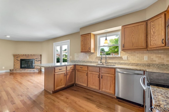 3100 Tally Ho Dr, Saint Charles, MO 63301 - kitchen with stainless steel appliances, a peninsula, light wood finished floors, and backsplash
