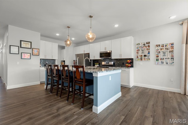 145 Royal Inverness Pkwy, Dardenne Prairie, MO 63368 - kitchen featuring appliances with stainless steel finishes, tasteful backsplash, dark wood-type flooring, a kitchen breakfast bar, and recessed lighting
