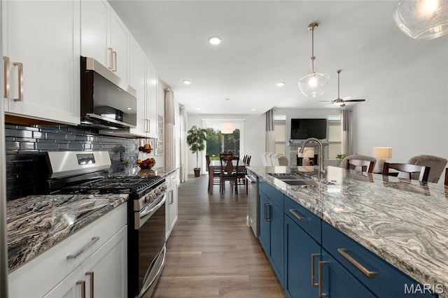 145 Royal Inverness Pkwy, Dardenne Prairie, MO 63368 - kitchen featuring appliances with stainless steel finishes, blue cabinetry, wood finished floors, white cabinets, and recessed lighting